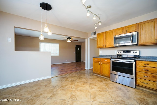 kitchen with dark countertops, visible vents, brown cabinetry, ceiling fan, and stainless steel appliances