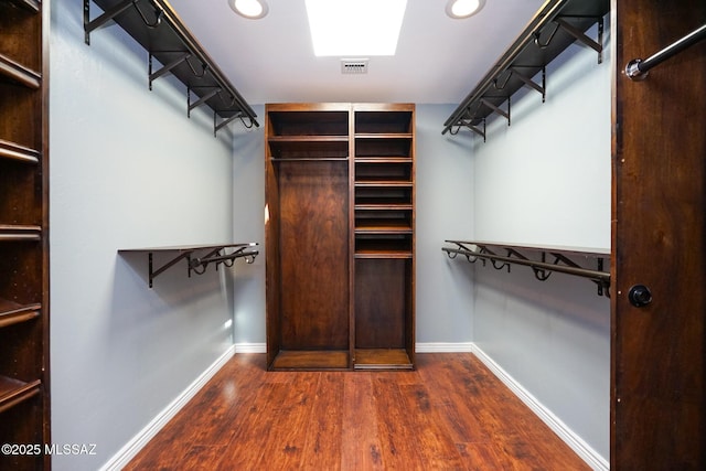 walk in closet featuring dark wood-style flooring and visible vents