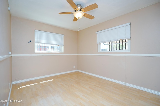 empty room featuring baseboards, a ceiling fan, and wood finished floors