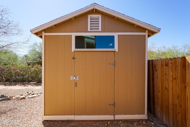 view of shed featuring fence