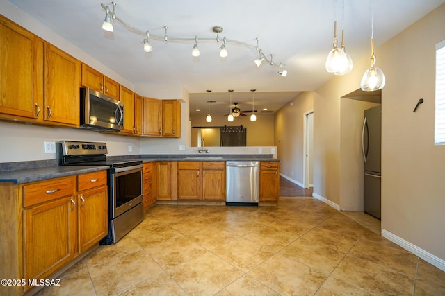kitchen featuring ceiling fan, appliances with stainless steel finishes, a sink, dark countertops, and brown cabinets
