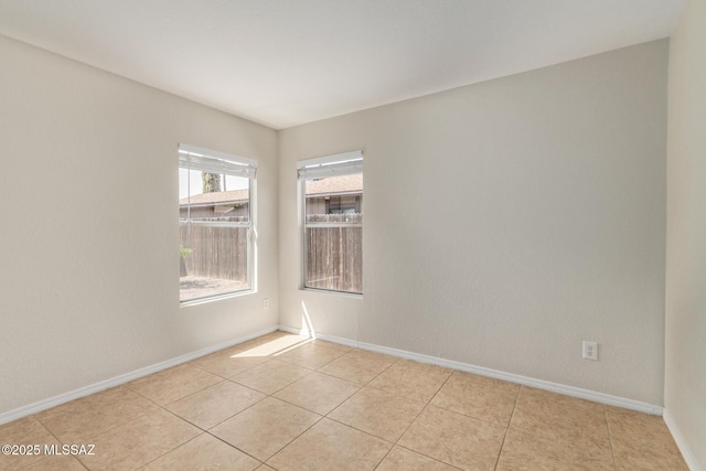 unfurnished room featuring light tile patterned floors and baseboards