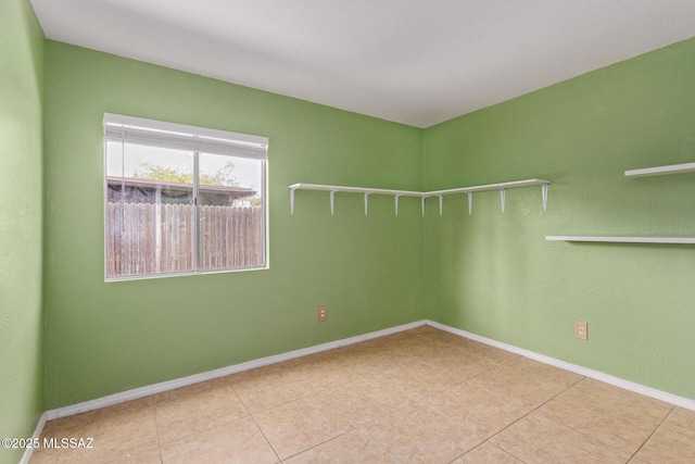 empty room featuring tile patterned flooring and baseboards