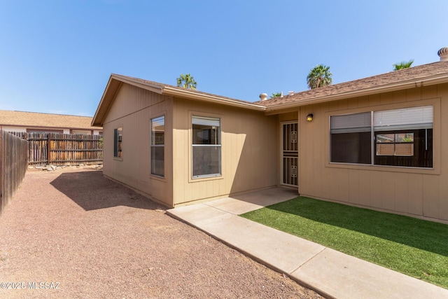 rear view of property with a fenced backyard and a patio area