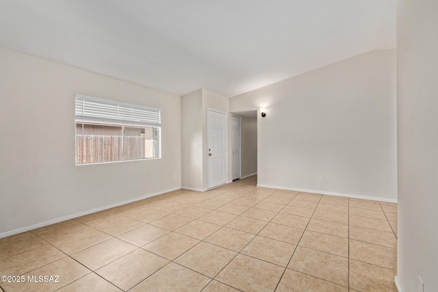 empty room with light tile patterned floors and baseboards