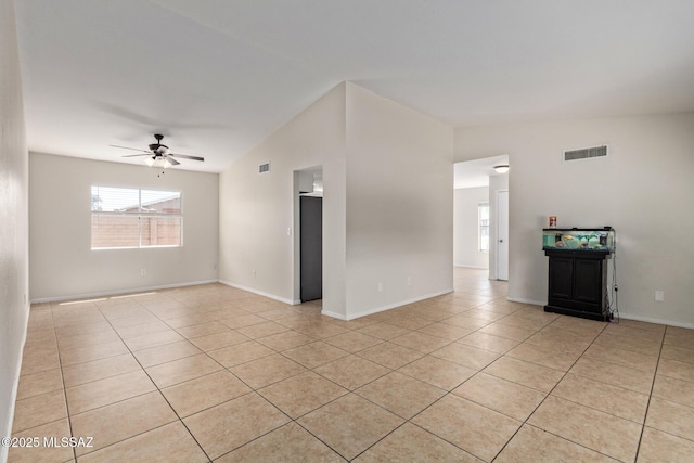 empty room with light tile patterned floors, visible vents, ceiling fan, and plenty of natural light