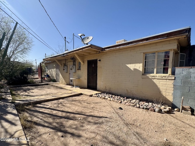 view of side of home featuring a patio area and concrete block siding