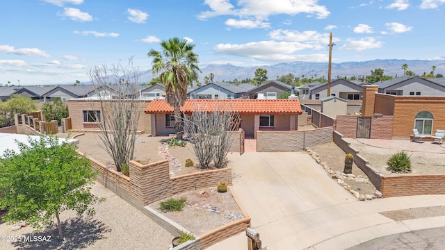 3216 S Winona Cir, Tucson, AZ 85730 - view of front facade featuring a residential view, a fenced front yard, a gate, a mountain view, and a tile roof