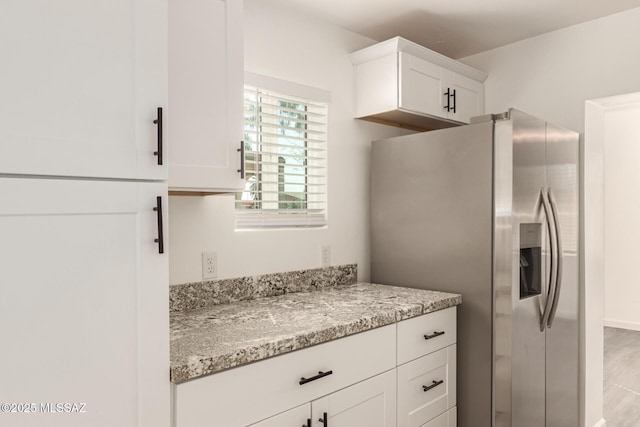 407 E 35th St, Tucson, AZ 85713 - kitchen with white cabinets, stainless steel fridge, and light stone countertops