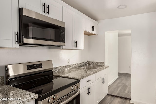 407 E 35th St, Tucson, AZ 85713 - kitchen featuring white cabinets, wood finished floors, appliances with stainless steel finishes, and a sink