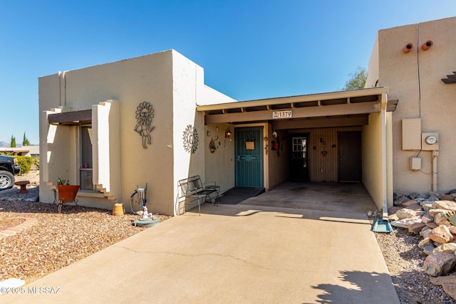 1379 W Camino Lucientes, Green Valley, AZ 85622 - pueblo revival-style home featuring a carport, stucco siding, and concrete driveway