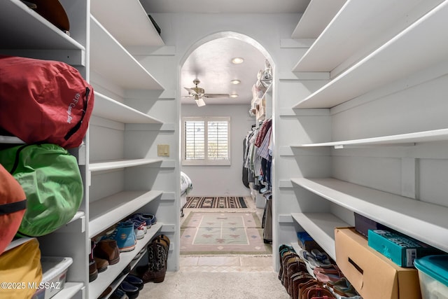 walk in closet with a ceiling fan