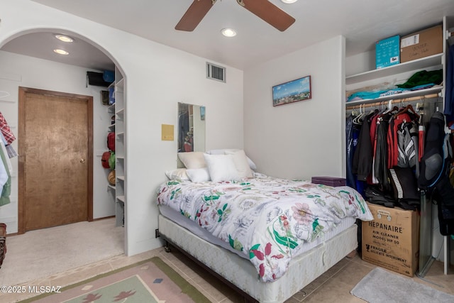 bedroom with arched walkways, a closet, visible vents, and recessed lighting