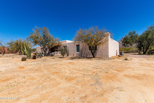 exterior space with central AC and stucco siding