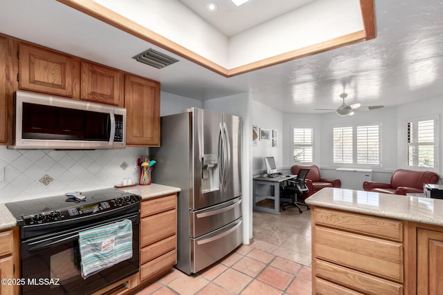 kitchen with open floor plan, appliances with stainless steel finishes, decorative backsplash, and visible vents