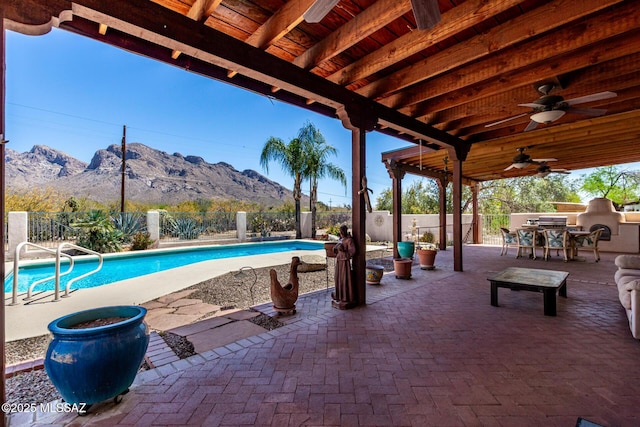 view of swimming pool featuring a patio, a mountain view, a fenced backyard, and outdoor dining area
