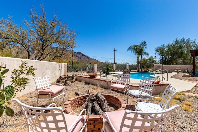 view of yard featuring a mountain view, a patio area, an outdoor fire pit, a fenced backyard, and a fenced in pool