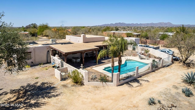 view of swimming pool featuring a mountain view, a fenced in pool, a patio area, and a fenced backyard