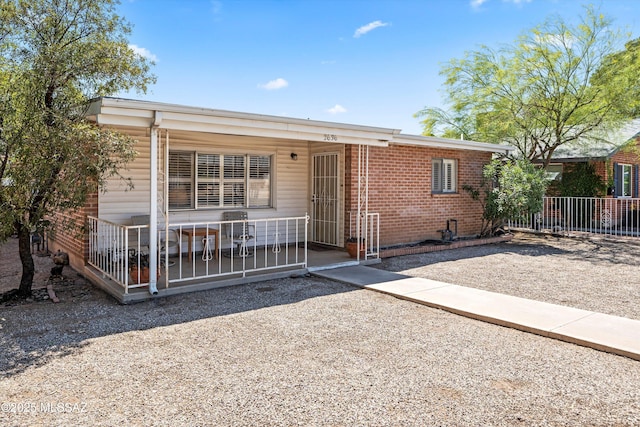2636 E 5th St, Tucson, AZ 85716 - view of front of property with brick siding, fence, and a porch