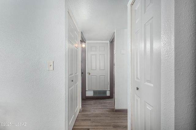 143 W Mossman Rd, Tucson, AZ 85706 - hallway featuring a textured wall, visible vents, baseboards, and wood finished floors