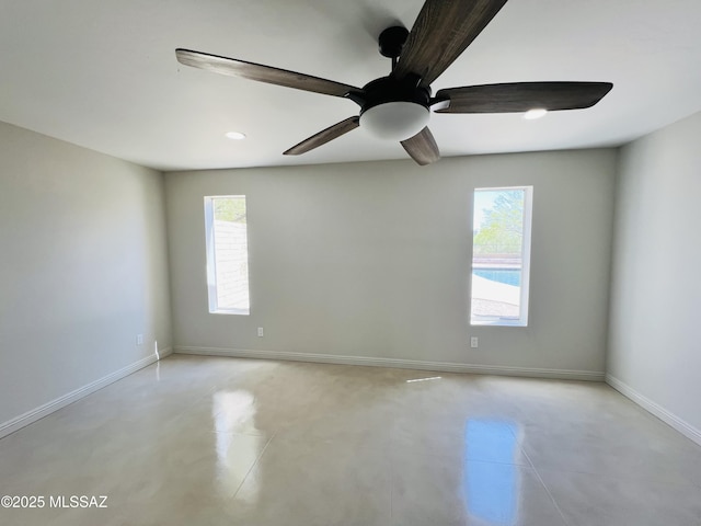 4250 E Aquarius Dr, Tucson, AZ 85718 - empty room featuring healthy amount of natural light, finished concrete flooring, baseboards, ceiling fan, and recessed lighting