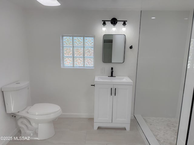 bathroom featuring vanity, baseboards, tile patterned floors, toilet, and a tile shower