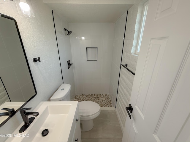 full bathroom with toilet, a stall shower, vanity, and a textured wall