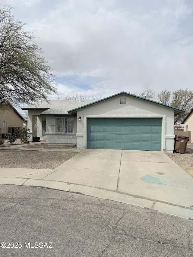 view of front of house featuring driveway, stucco siding, and an attached garage