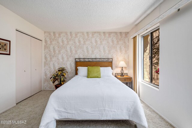 carpeted bedroom featuring a closet and a textured ceiling