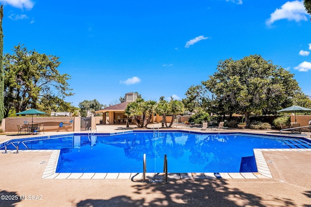 community pool featuring a patio area and fence