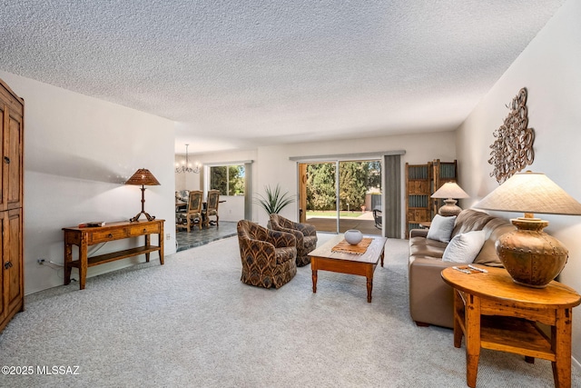 living room featuring a chandelier, light colored carpet, and a textured ceiling