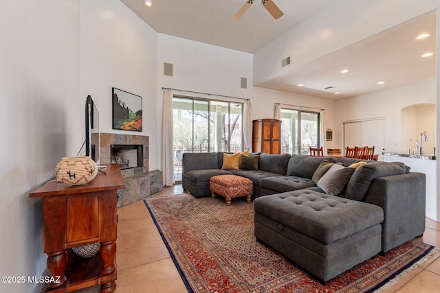 738 S Tohono Ridge Pl, Tucson, AZ 85745 - living room featuring a high ceiling, ceiling fan, recessed lighting, arched walkways, and a tiled fireplace