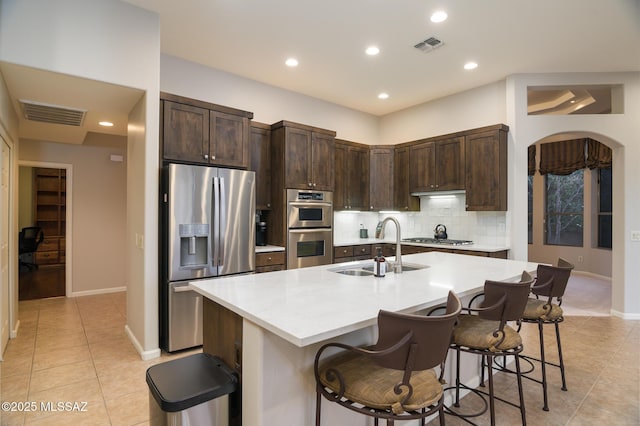 37717 S Terrace Park Dr, Saddlebrooke, AZ 85739 - kitchen featuring stainless steel appliances, a sink, light tile patterned floors, dark brown cabinets, and recessed lighting