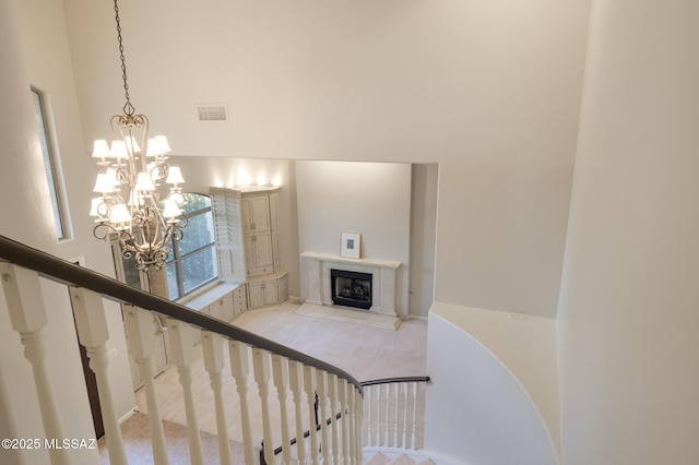 37717 S Terrace Park Dr, Saddlebrooke, AZ 85739 - staircase featuring a chandelier, carpet flooring, a premium fireplace, and a towering ceiling