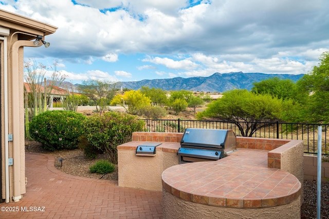 37717 S Terrace Park Dr, Saddlebrooke, AZ 85739 - view of patio / terrace featuring exterior kitchen, a grill, a mountain view, and fence
