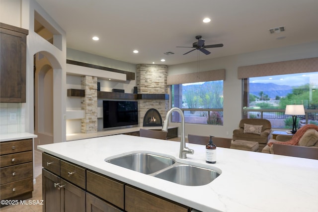 37717 S Terrace Park Dr, Saddlebrooke, AZ 85739 - kitchen with open floor plan, a sink, a ceiling fan, recessed lighting, and a stone fireplace