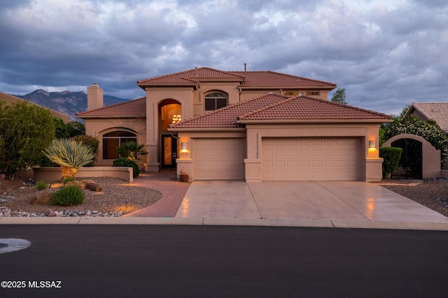 37717 S Terrace Park Dr, Saddlebrooke, AZ 85739 - mediterranean / spanish home featuring an attached garage, stucco siding, concrete driveway, a tile roof, and a mountain view