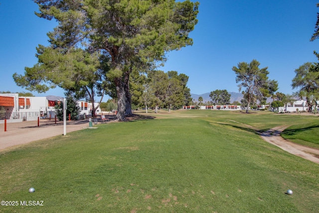 view of property's community featuring a lawn, a residential view, a mountain view, and golf course view