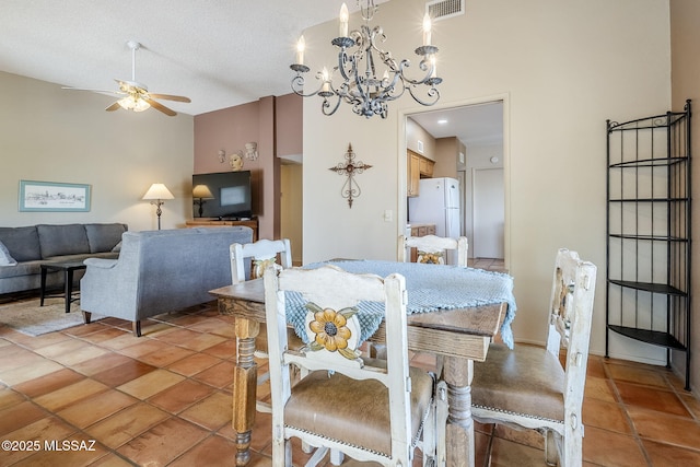 dining space with light tile patterned floors, visible vents, ceiling fan with notable chandelier, and a textured ceiling