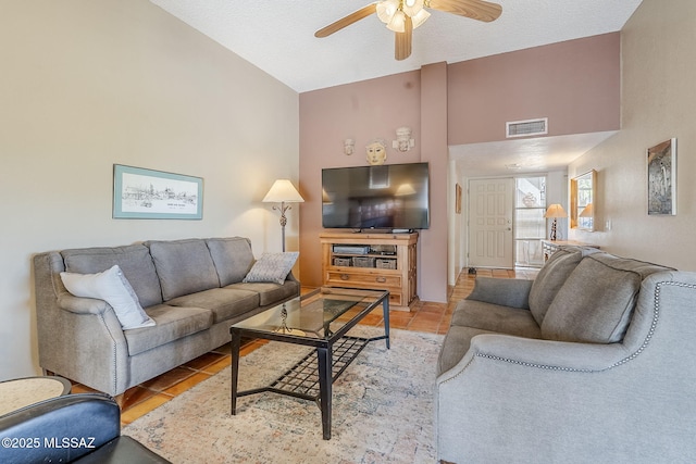 living room with high vaulted ceiling, light tile patterned floors, visible vents, and a ceiling fan