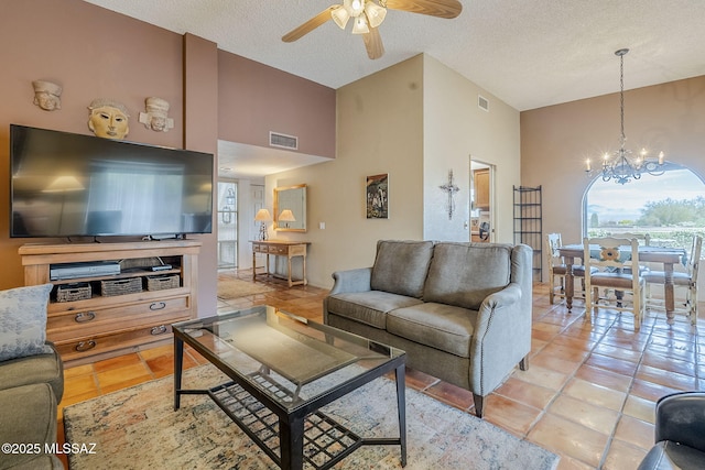 living room featuring ceiling fan with notable chandelier, high vaulted ceiling, visible vents, and light tile patterned floors