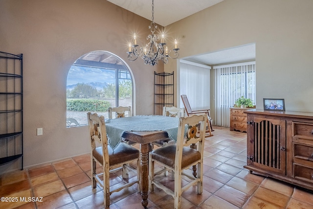 dining space featuring a chandelier, a healthy amount of sunlight, light tile patterned flooring, and lofted ceiling