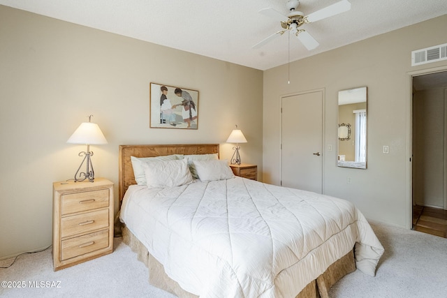 bedroom featuring light carpet, visible vents, and a ceiling fan