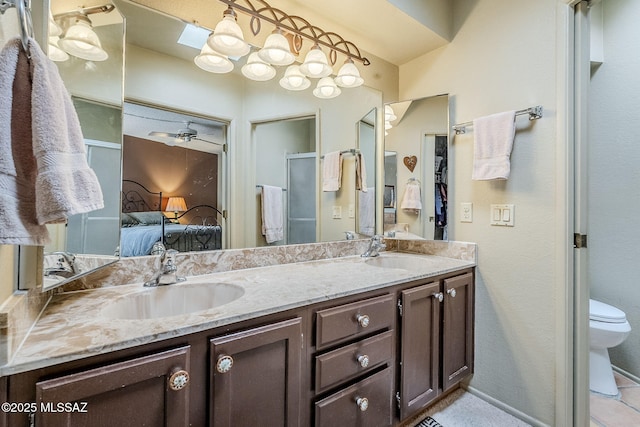 ensuite bathroom featuring toilet, double vanity, a sink, and ensuite bath