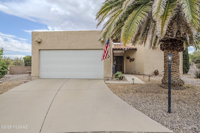 view of front of house featuring an attached garage, driveway, and stucco siding