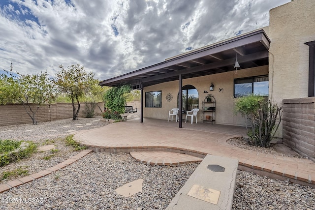 back of house with a patio area, a fenced backyard, and stucco siding