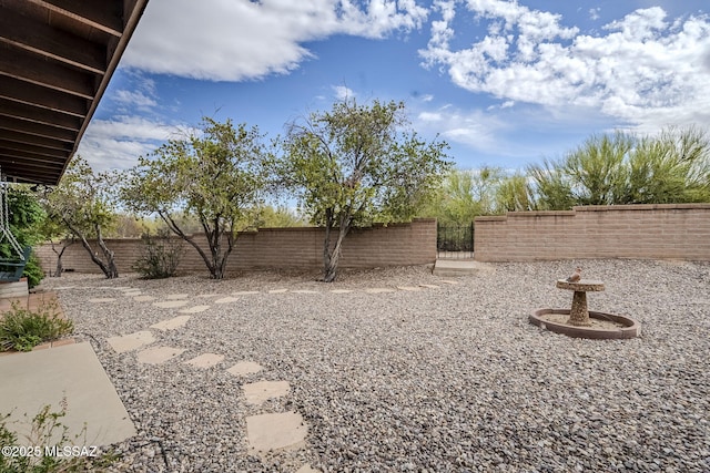view of yard featuring a fenced backyard and a gate