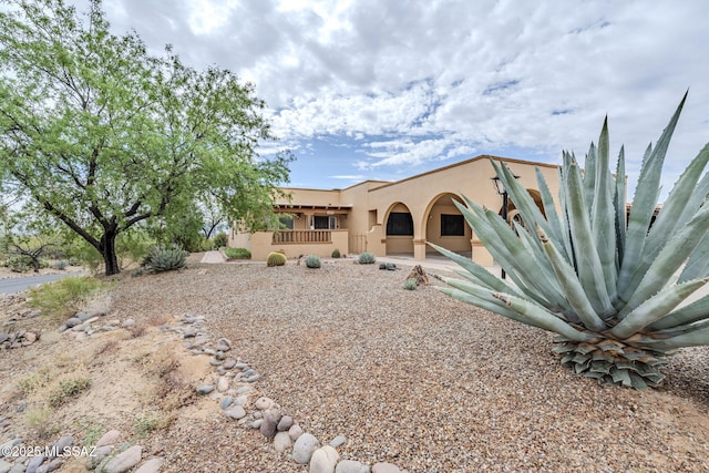 view of front of house featuring stucco siding and a porch