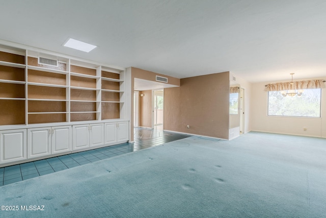 unfurnished living room with tile patterned floors, visible vents, an inviting chandelier, and carpet