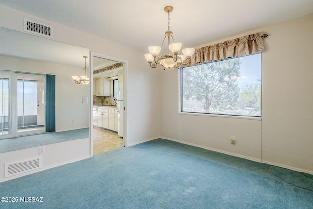 empty room with a chandelier, visible vents, and light carpet